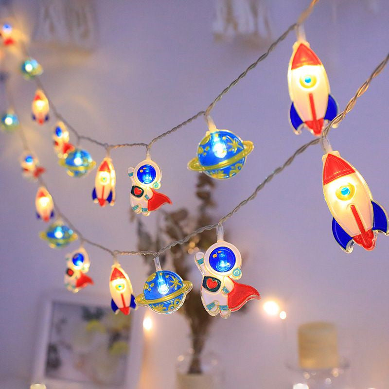 String lights with space-themed decorations including rockets and planets on a neutral background.