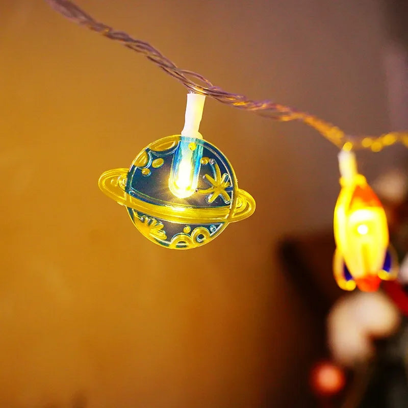 String lights with planet and rocket designs on a warm-toned background