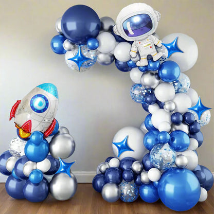 Balloon arch with astronaut and rocket design, featuring blue, white, and silver balloons.