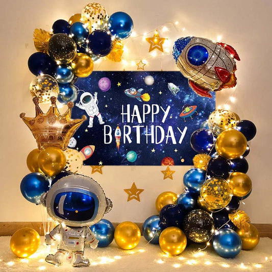 Space-themed birthday balloon arch with 'Happy Birthday' sign and astronaut decorations.