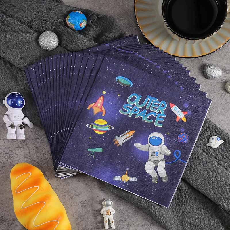 Stack of napkins with space-themed illustrations on a textured surface.