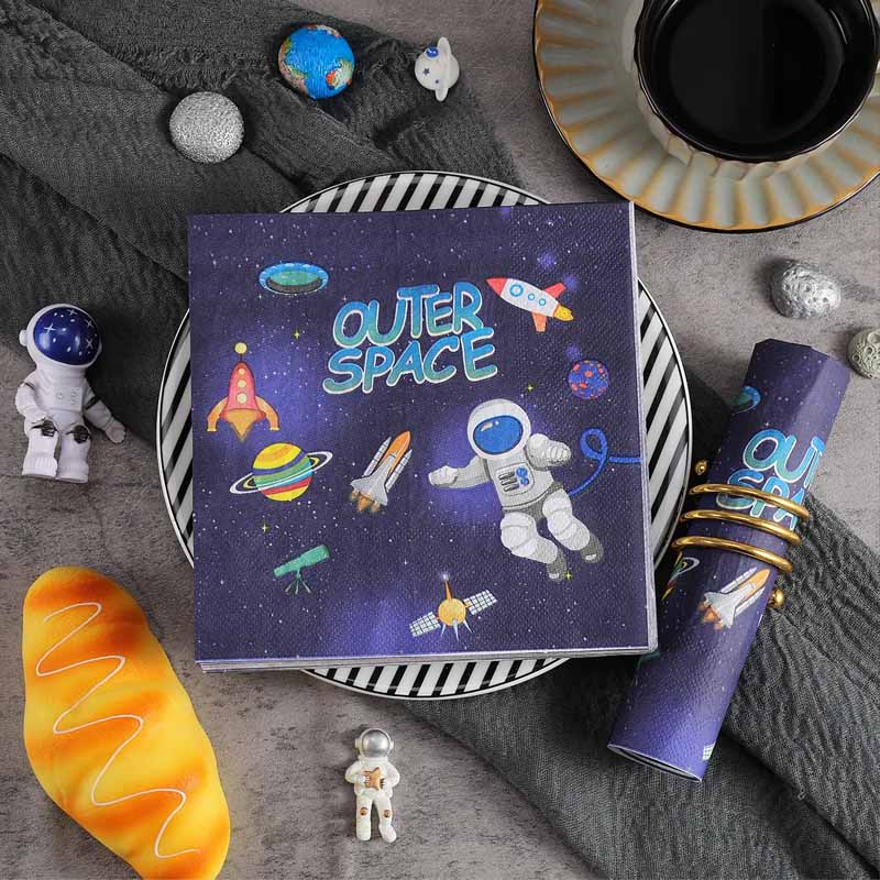 Napkins with cosmic illustrations on a gray surface with space-themed toys.