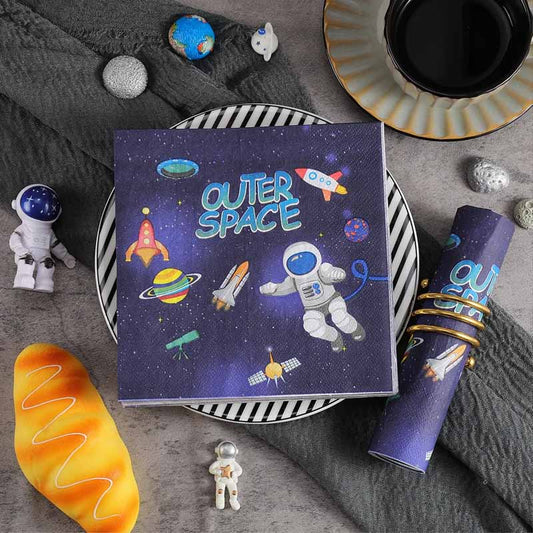 Napkins with cosmic illustrations on a gray surface with space-themed toys.
